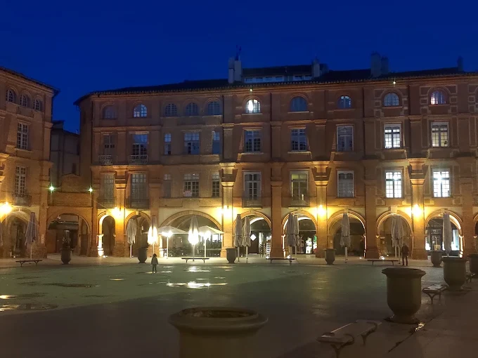 Place à arcades dans le centre de Montauban la nuit